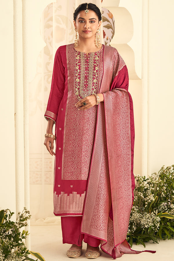 Woman wearing a traditional pink embroidered outfit with a white background